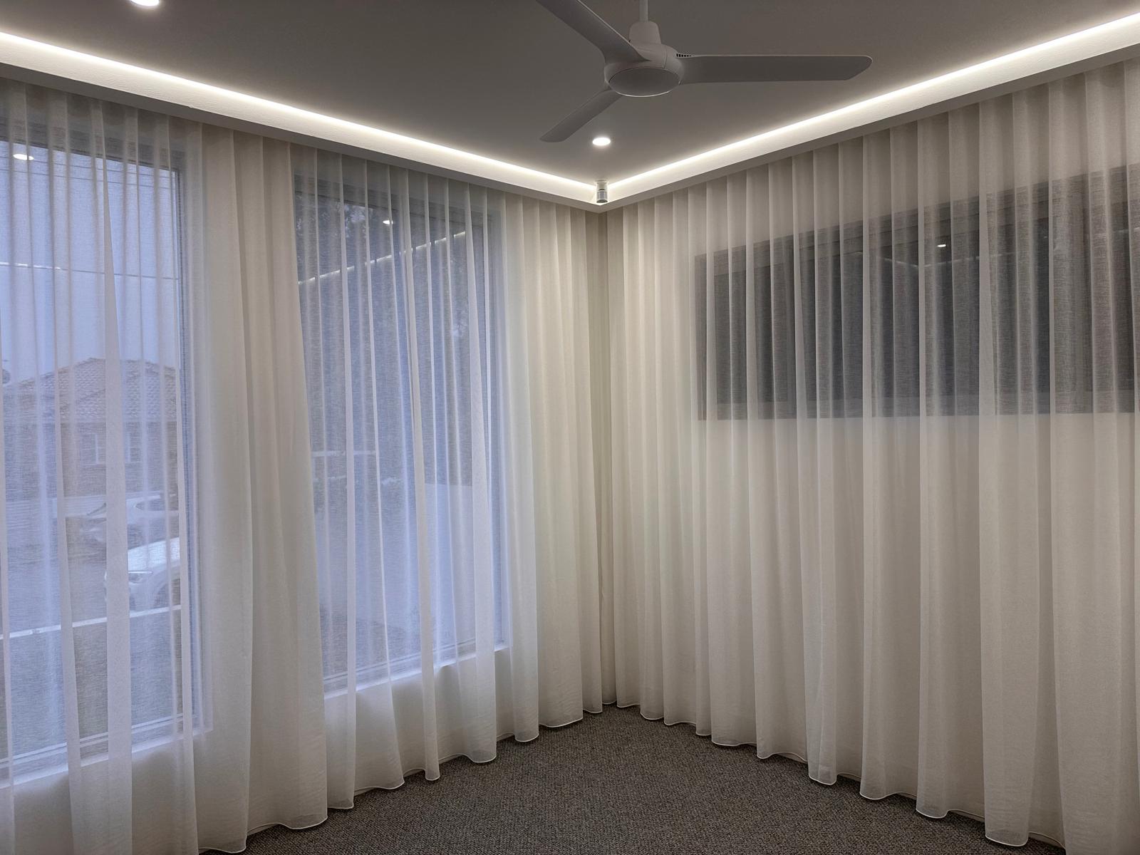 Layered sheer curtains paired with blockout roller blinds for maximum privacy